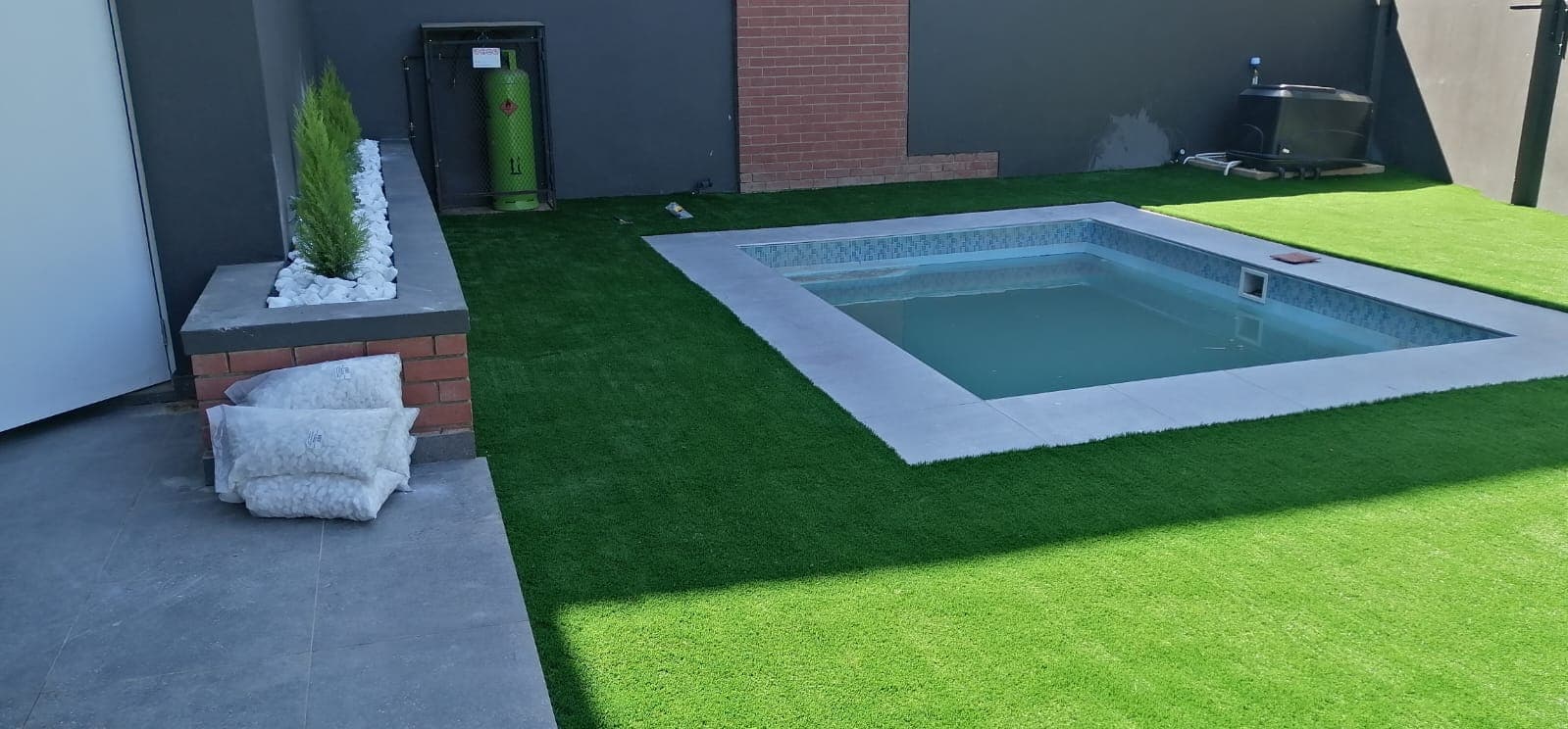 Plunge pool with artificial lawn surround and raised planter in Midrand